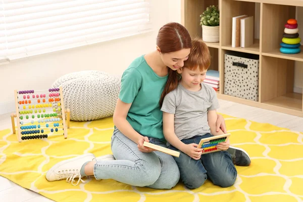 快乐的母亲和儿子在房间的地板上玩不同的数学游戏套件 愉快地学习数学 — 图库照片