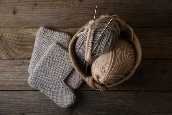 stock image Soft colorful yarns, knitted socks and metal needles on wooden table, flat lay