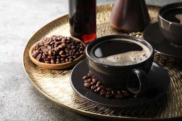 stock image Delicious syrup, cup of coffee and beans on grey table