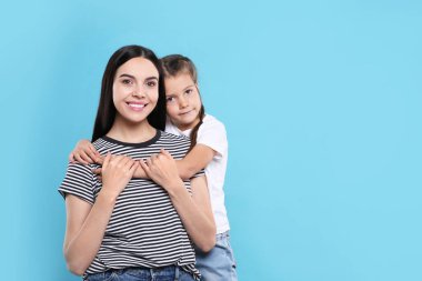 Açık mavi arka planda kızı olan mutlu bir kadın. Mesaj için yer var. Anneler günü kutlaması.