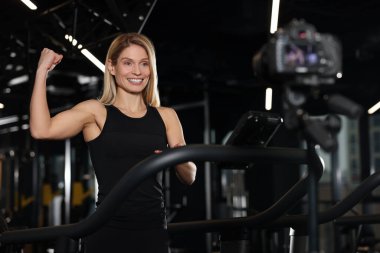 Fitness trainer recording online classes in gym