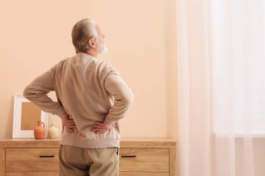 Evde acıdan muzdarip olan yaşlı bir adam, mesaj için yeri olan bir arka plan. Artrit belirtileri