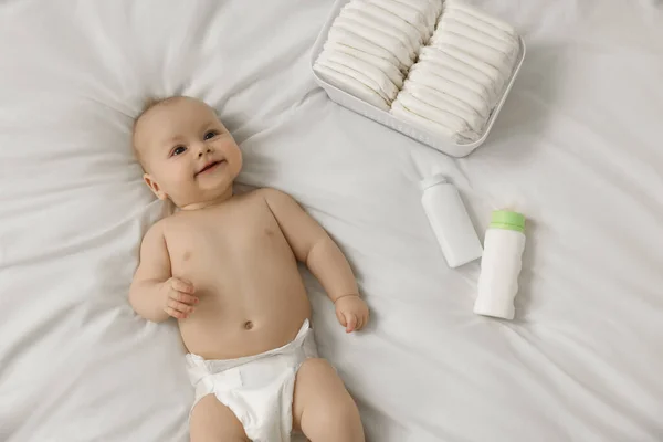 Χαριτωμένο Μωρό Πάνες Και Καλλυντικά Προϊόντα Λευκό Κρεβάτι Top View — Φωτογραφία Αρχείου