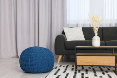 Rahat mobilyalar ve güzel pencere perdeleri olan şık bir oturma odası.