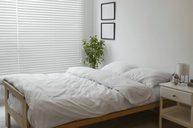 Geceleri rahat yatağı ve komodinin olduğu şık bir oda. İç tasarım