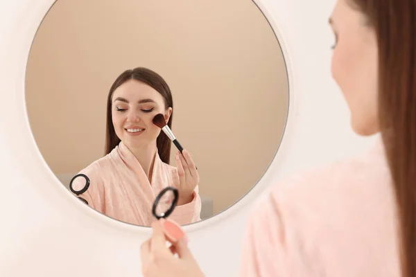 Vacker Ung Kvinna Tillämpa Rouge Med Borste Nära Spegel Inomhus — Stockfoto