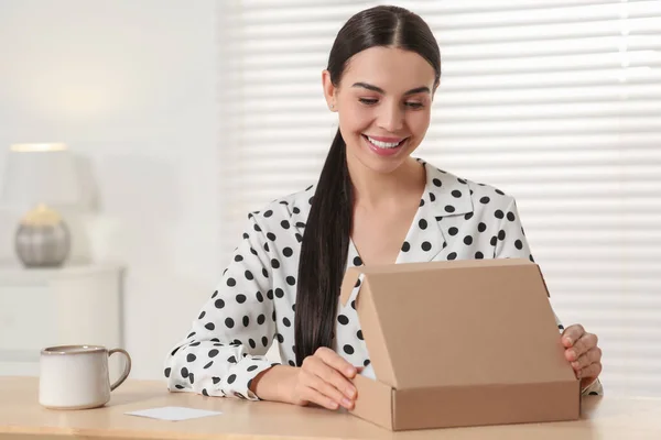Glad Ung Kvinna Öppnar Paket Vid Bordet Inomhus Internet Shopping — Stockfoto