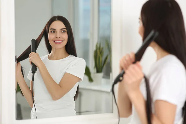 Vacker Lycklig Kvinna Med Hjälp Hår Järn Nära Spegel Rummet — Stockfoto