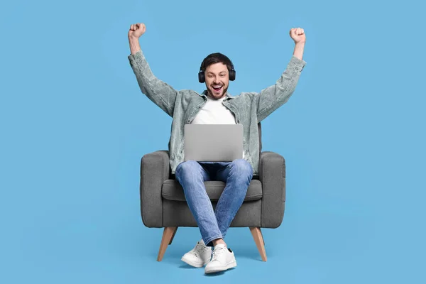 Homem Feliz Com Laptop Fones Ouvido Poltrona Fundo Azul Claro — Fotografia de Stock