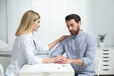 Klinikteki beyaz masada danışmanlık yapan bir doktor.