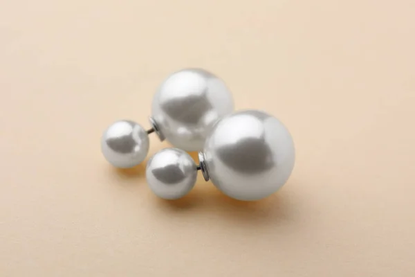 米色背景上镶嵌珍珠的精致耳环 — 图库照片