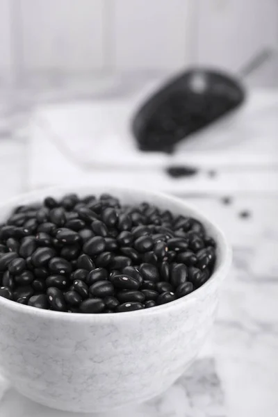 stock image Bowl of raw black beans on white marble table, closeup