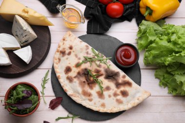 Lezzetli calzone ve hafif ahşap masa üzerindeki ürünler, düz yatıyordu.