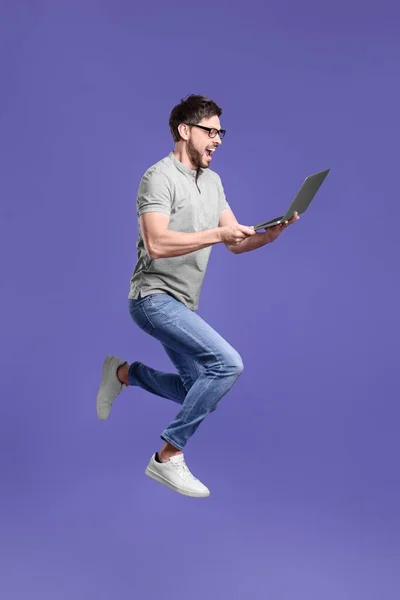 Homem Feliz Com Laptop Pulando Fundo Lilás — Fotografia de Stock
