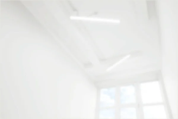 Empty room with white walls and window, blurred view