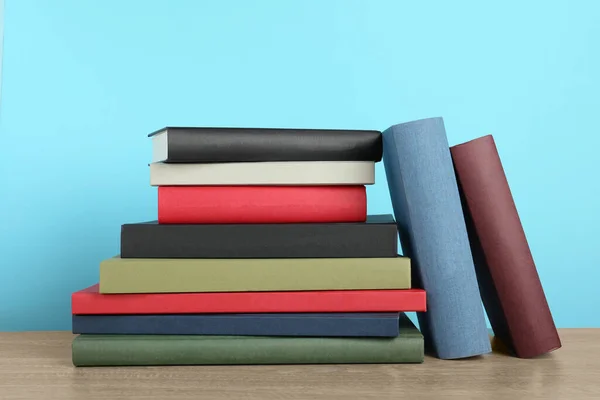Många Inbundna Böcker Träbord Nära Ljusblå Vägg — Stockfoto