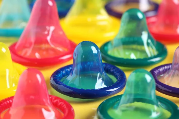 stock image Colorful condoms on yellow background, closeup view