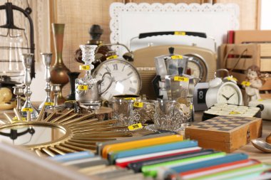 Many different items on wooden table. Garage sale