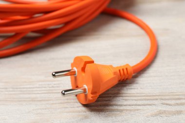 Beyaz ahşap zemindeki uzatma kablosu, yakın plan. Elektrikçi ekipmanı.