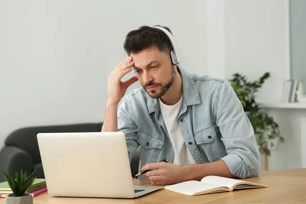 在家里用笔记本电脑学习的戴耳机的男人 在线翻译课程 — 图库照片