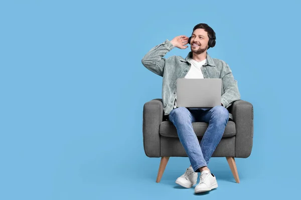 Homem Feliz Com Laptop Fones Ouvido Sentado Poltrona Fundo Azul — Fotografia de Stock