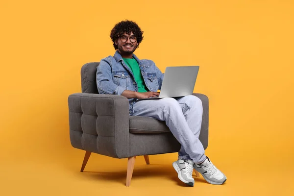 Sorrindo Homem Com Laptop Sentado Poltrona Fundo Amarelo — Fotografia de Stock