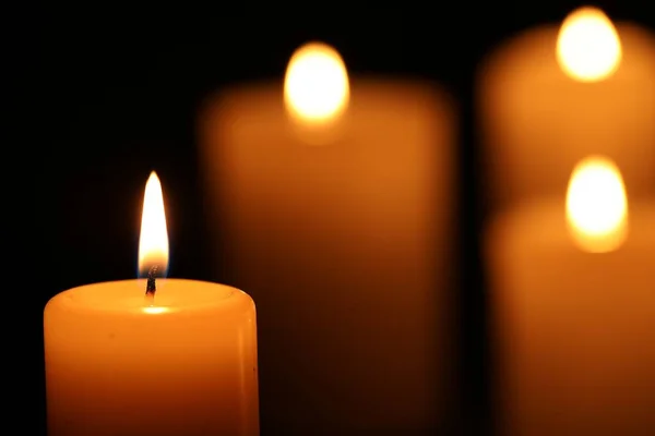 stock image Burning candles on black background, closeup. Space for text