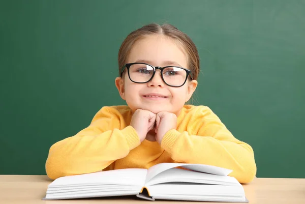 Šťastné Malé Školní Dítě Sedí Stolem Knihou Tabule — Stock fotografie