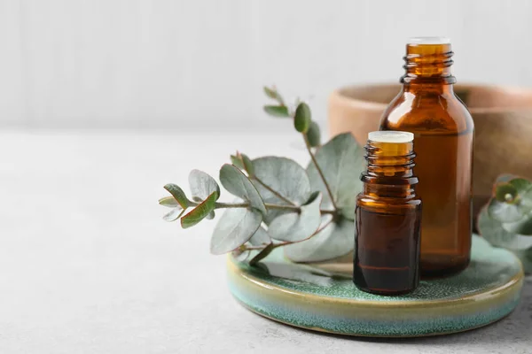 Flaschen Mit Ätherischem Eukalyptusöl Und Pflanzenzweigen Auf Weißem Tisch Platz — Stockfoto