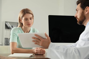 Klinikteki ahşap masada bir doktora danışıyorum.