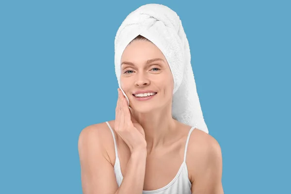 Piękna Kobieta Ręczniku Frotte Usuwanie Makijażu Podkładką Bawełnianą Jasnoniebieskim Tle — Zdjęcie stockowe
