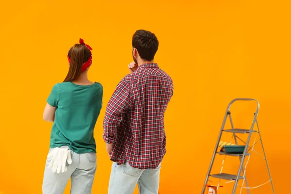 Diseñadores Mirando Pared Color Naranja Recién Pintado Vista Trasera — Foto de Stock