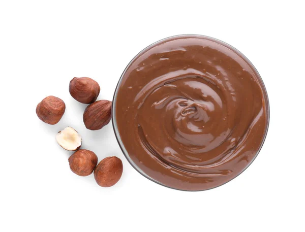 美味可口的巧克力酱和背景为白色的榛子的碗 顶视图 — 图库照片