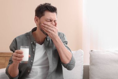 Süt bardağı olan bir adam evde laktoza duyarlılıktan muzdarip.