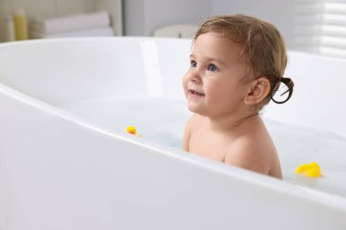 Tatlı küçük kız evde banyo yapıyor.