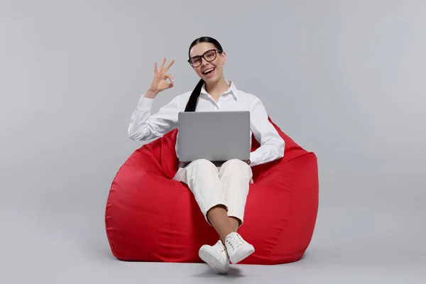 Glückliche Frau Mit Laptop Sitzt Auf Sitzsack Stuhl Und Zeigt — Stockfoto