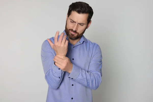 Hombre Sufriendo Dolor Mano Sobre Fondo Claro Síntomas Artritis —  Fotos de Stock