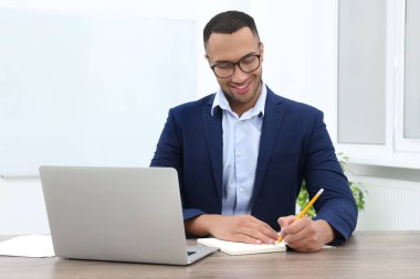 Modern ofisteki masada çalışan mutlu genç stajyer.