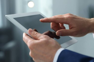 Kapalı alanda yeni tablet kullanan adamın yakın görüntüsü