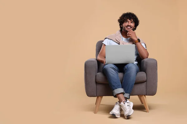 Sorrindo Homem Com Laptop Sentado Poltrona Fundo Bege Espaço Para — Fotografia de Stock