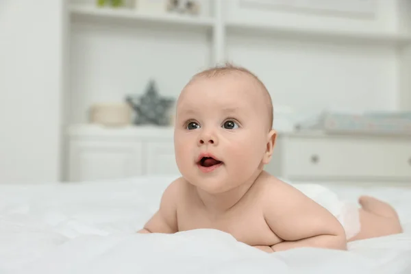 stock image Cute baby lying on white bed at home, space for text