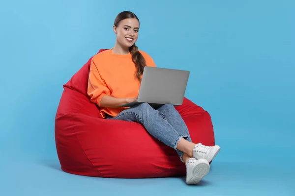 Mulher Feliz Com Laptop Sentado Cadeira Beanbag Contra Fundo Azul — Fotografia de Stock