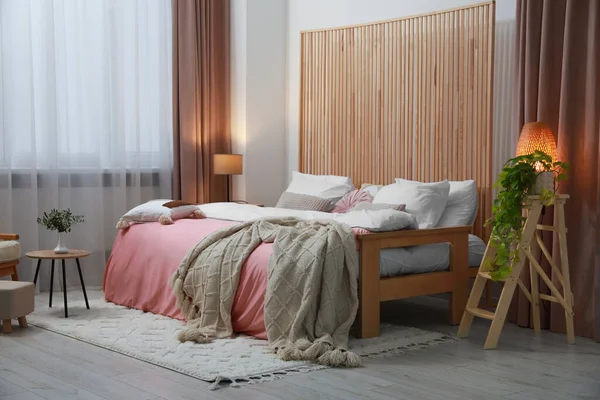 Elegante Dormitorio Con Cama Cómoda Mesa Madera Plantas Interior Diseño —  Fotos de Stock