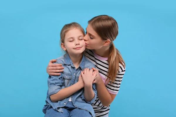 Jovem Mulher Beijando Sua Filhinha Fundo Azul Claro Feliz Dia — Fotografia de Stock