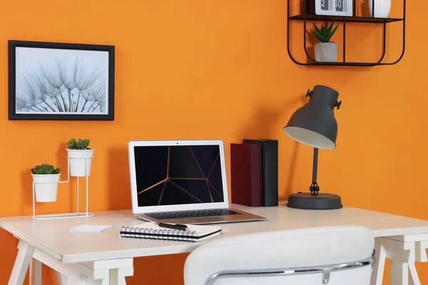 Modern Laptop Books Lamp Stationery Wooden Desk Orange Wall Home — Stock Photo, Image