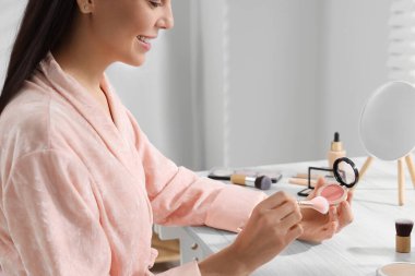 Yüzü kızaran ve tuvalet masasını fırçalayan kadın, yakın plan.