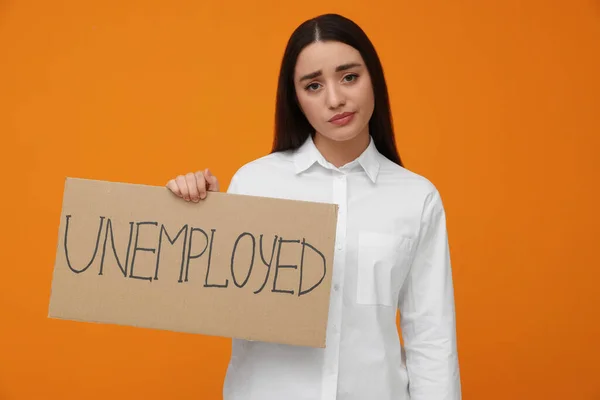 Young Woman Holding Sign Word Unemployed Orange Background — Foto Stock