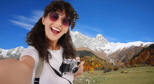 美しいです女性でサングラスとともにカメラ取ります自己山の中で — ストック写真