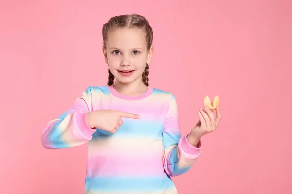 Девушка Указывает Вкусное Печенье Предсказанием Розовом Фоне — стоковое фото
