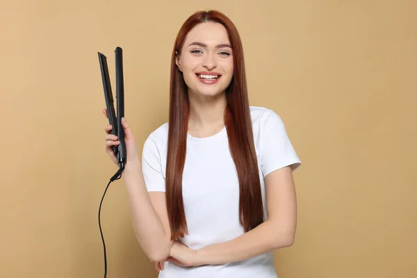 Bej Arka Planda Saç Ütüsü Olan Güzel Bir Kadın — Stok fotoğraf